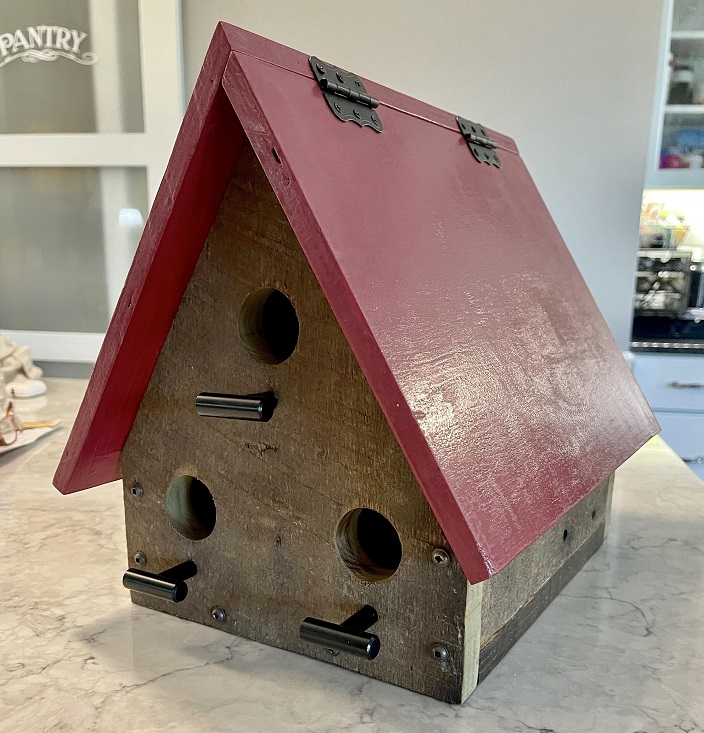 A frame bird house with a red roof